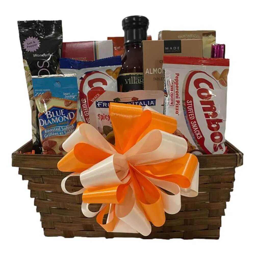 Gift Basket with snacks including Combos, Blue Diamond nuts, BBQ sauce, and chocolates in a woven basket with orange and white ribbon bow